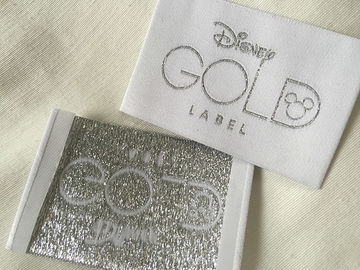 A roupa tecida dobra da extremidade de Bage do ouro de Disney etiqueta o corte frio/corte do calor