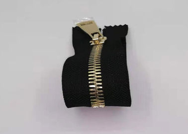 O metal dos dentes da cor do ouro fecha para sacos/zíperes resistentes do metal